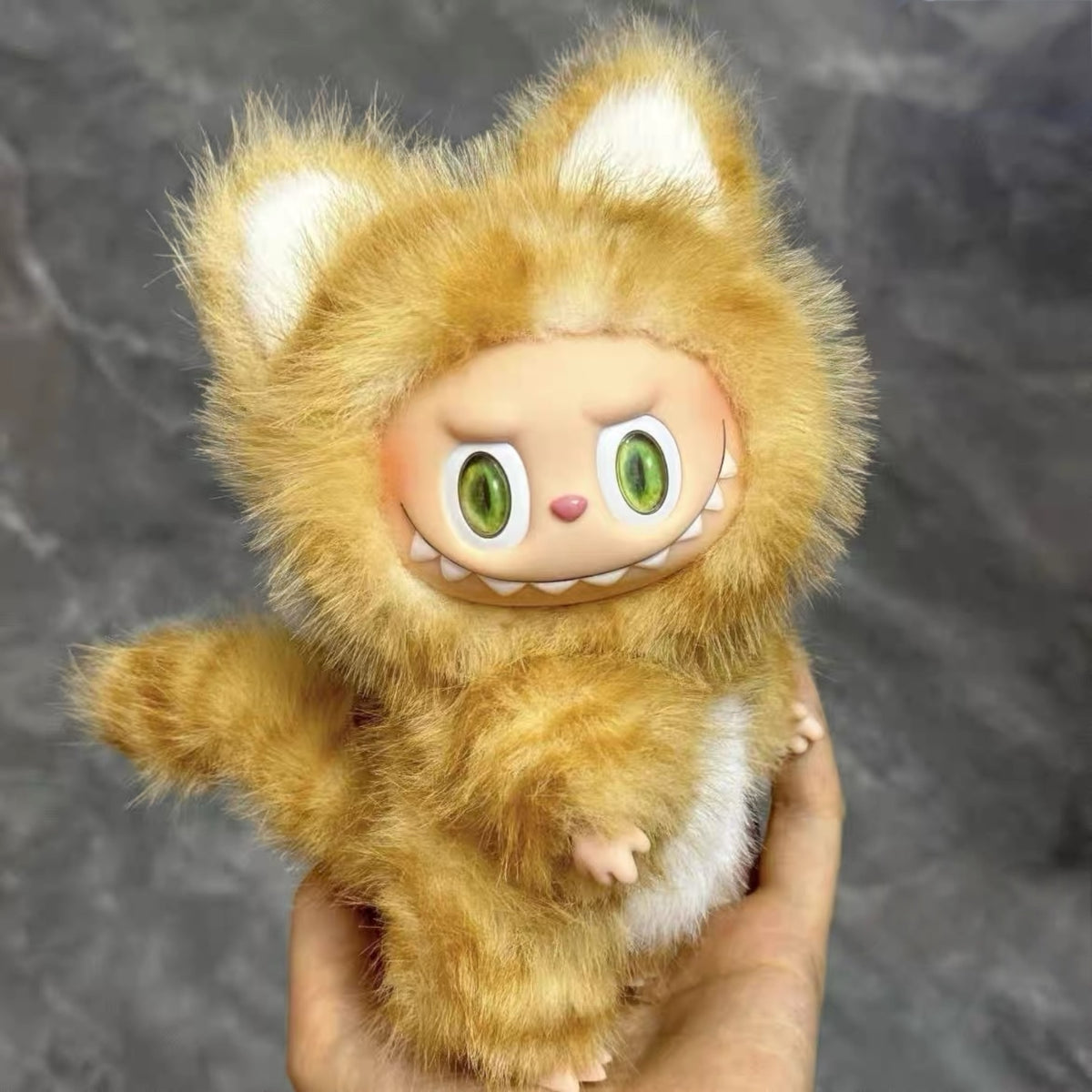 A Labubu Doll wearing a golden cat costume with a gray background