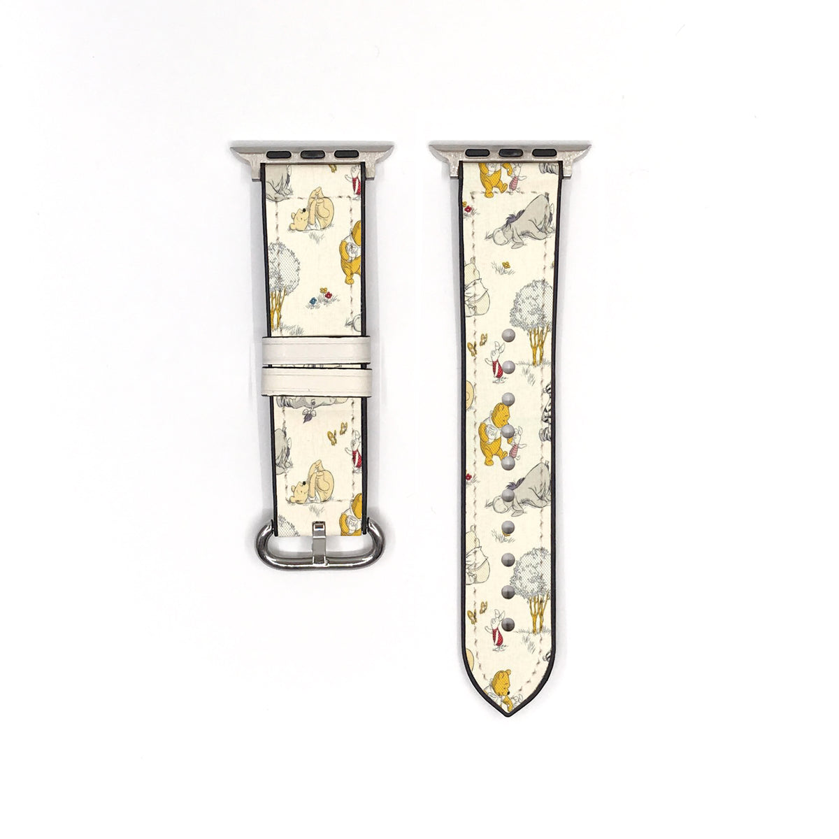 Cream character-print Apple Watch band showing both strap pieces and silver-tone fastening hardware.