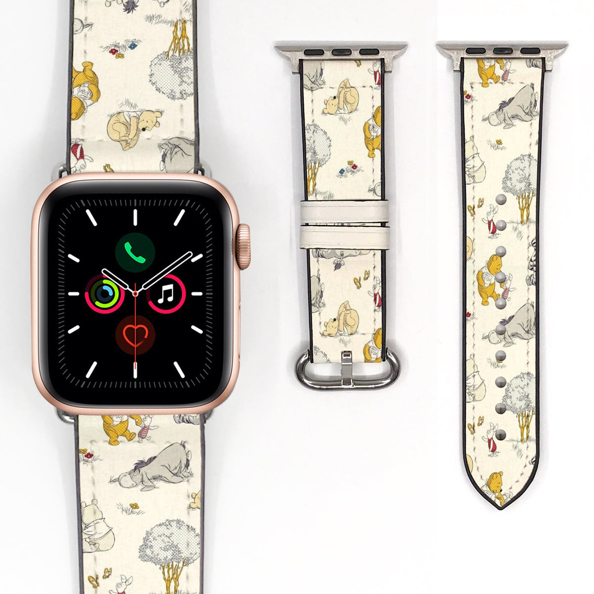 Close-up of a cream storybook character Apple Watch band with delicate woodland illustrations and silver-tone hardware.