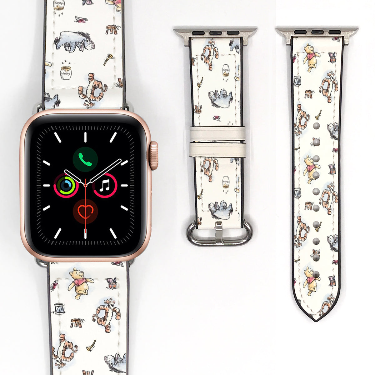 Close-up of a cream Winnie the Pooh watch band featuring Pooh, Tigger, Eeyore, and storybook-inspired illustrations.
