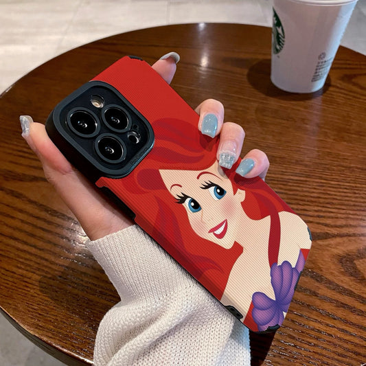 My Little Mermaid Ariel iPhone case with a character design held by a hand on a wooden table with a Starbucks cup in the background.