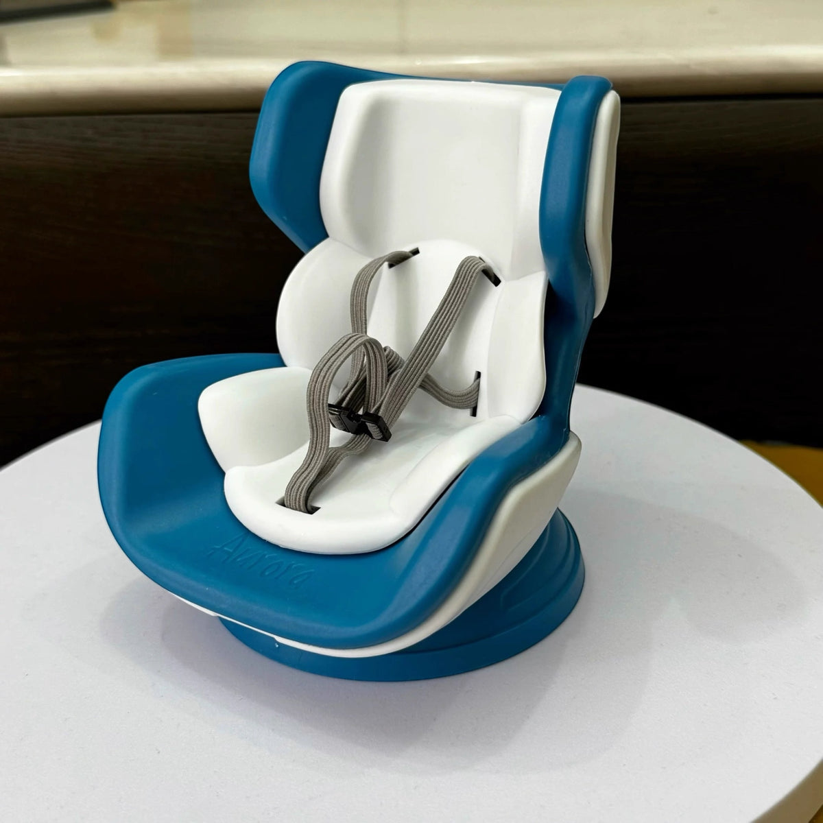 Blue and white baby high chair on a white surface with a blurred background