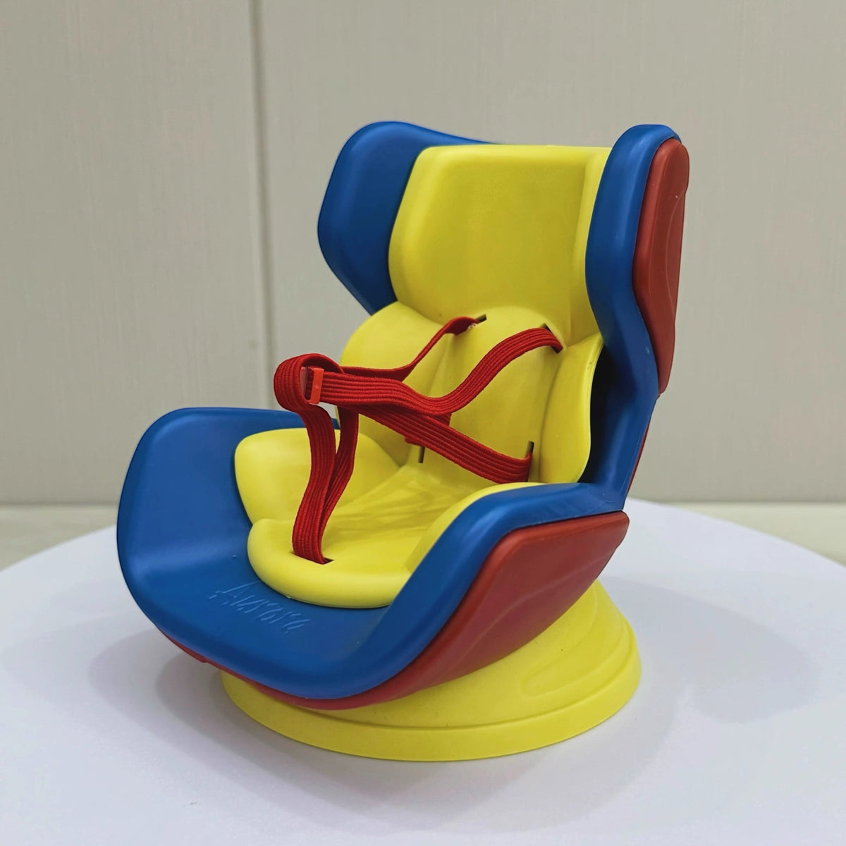 Colorful baby seat with blue, yellow, and red design on a white surface.