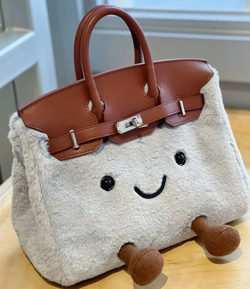 Side view of a gray fluffy character handbag with brown trim