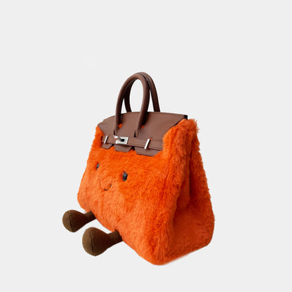 Side view of a mini orange fluffy handbag with brown character feet